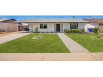 Charming single-story home boasts a manicured lawn and inviting brick pathway to the front door at 1058 E 2Nd St, Mesa, AZ 85203
