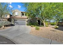 Inviting home exterior featuring a two-car garage, desert landscaping, and tile roof at 21105 N 37Th Run, Phoenix, AZ 85050
