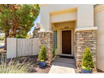 Inviting front entrance with a wooden door, stone pillars, and decorative potted plants at 2129 E Beautiful Ln, Phoenix, AZ 85042
