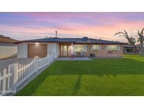 Inviting single-story home with well-kept lawn, neutral stucco, brick accents and small seating area at 2234 N 74Th Way, Scottsdale, AZ 85257