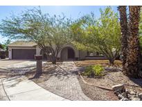 Charming single-Gathering home with mature trees, brick walkway, and lush landscaping at 3061 W Betty Elyse Ln, Phoenix, AZ 85053