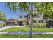 Charming two-story home featuring a lush green lawn, mature trees, and a well-maintained exterior at 3062 E Cullumber St, Gilbert, AZ 85234