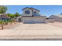 Charming two-story home showcasing a three car garage and desert landscaping at 4933 E Downing St, Mesa, AZ 85205