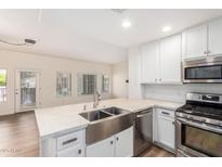 Modern kitchen with stainless steel appliances, white cabinets, and a double basin sink at 5450 E Deer Valley Dr # 1211, Phoenix, AZ 85054