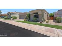 Inviting home featuring a desert landscape, two car garage, and tan exterior at 8541 E Krail St, Scottsdale, AZ 85250
