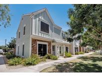 Charming two-story townhome with light-blue wood siding and a brick accent on the lower level at 1600 N Saba St # 214, Chandler, AZ 85225
