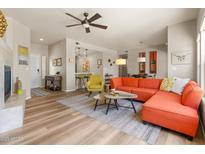 Bright living room boasts a fireplace, wood floors, and contemporary furnishings at 19700 N 76Th St # 1038, Scottsdale, AZ 85255