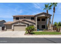Two-story home featuring desert landscaping, a three-car garage, and a covered porch at 20226 N Madison Dr, Maricopa, AZ 85138