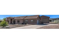 Charming single-story home with a stone and stucco exterior, tile roof, desert landscaping, and a long driveway at 20911 E Excelsior Ave, Queen Creek, AZ 85142