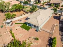 Aerial view of backyard with desert landscaping, fire pit, outdoor kitchen, and artificial grass at 41793 W Canasta Ln, Maricopa, AZ 85138