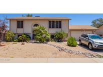 Two-story home with desert landscaping, a basketball hoop, and a beige stucco exterior at 7259 E Glencove St, Mesa, AZ 85207