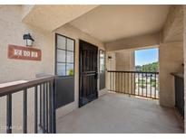 Inviting condo front entrance with a balcony, a secure screen door, and an exterior light at 8314 N 21St Dr # K208, Phoenix, AZ 85021