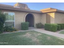 Charming brick home featuring an arched entryway and neatly manicured landscaping at 1036 E Wagon Wheel Dr, Phoenix, AZ 85020