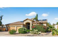 Charming single-story home with desert landscaping, a three-car garage, and solar panels at 10897 S Turtle Dove S Dr, Goodyear, AZ 85338