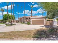 Expansive estate featuring a circular driveway and lush landscaping, creating a grand entrance at 1338 E Greenway Cir, Mesa, AZ 85203