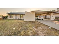Charming single-story home featuring a carport, desert landscaping, and solar panels for energy efficiency at 13802 N 37Th Dr, Phoenix, AZ 85053