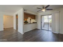 Open-concept living room boasts sliding glass doors to the balcony and breakfast bar to the kitchen at 1402 E Guadalupe Rd # 122, Tempe, AZ 85283