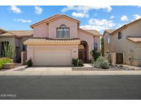 Charming two-story home with a tile roof, desert landscaping, and a two-car garage at 14186 N 100Th Pl, Scottsdale, AZ 85260