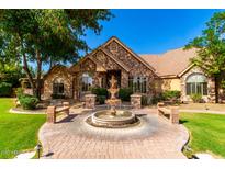 Stunning stone home with a circular driveway and a beautiful water fountain feature at 2558 E Page Ct, Gilbert, AZ 85234
