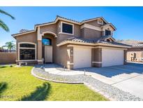 Beautiful two-story home with a well-manicured front yard and a three-car garage at 25818 N 68Th Ave, Peoria, AZ 85383
