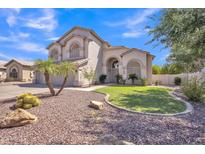 Stunning two-story home boasts arched windows, a three-car garage, and lush landscaping with palm trees and desert plants at 2642 S Joplin --, Mesa, AZ 85209