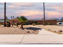 Charming single-story home featuring desert landscaping, a walkway, and a classic brick facade under a colorful sky at 533 E 7Th Pl, Mesa, AZ 85203