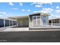 Charming manufactured home with a carport and well-maintained landscaping at 650 N Hawes Rd # 3424, Mesa, AZ 85207