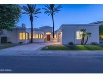 Stunning modern home exterior at dusk with lush landscaping and a circular driveway at 7878 E Gainey Ranch Rd # 36, Scottsdale, AZ 85258