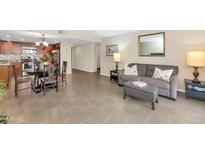 Open living room boasts tile flooring, comfortable seating, and seamless flow into the adjacent dining and kitchen areas at 7960 E Camelback Rd # 409, Scottsdale, AZ 85251