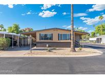Charming single-story home featuring a covered carport and well-maintained gravel landscaping at 11411 N 91St Ave Ave # 87, Peoria, AZ 85345