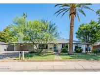 Charming single-story home with mature trees and a well-manicured lawn at 314 E Royal Palm Rd, Phoenix, AZ 85020