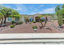 Inviting single-story home featuring desert landscaping and palm trees in the front yard at 5949 W Pinnacle Hill Dr, Glendale, AZ 85310