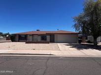 Charming single-story home features a low-maintenance gravel front yard, wide driveway, and attached two-car garage at 662 W Laguna Azul Ave, Mesa, AZ 85210