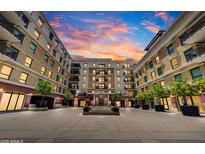 Exterior courtyard with fountain and manicured landscaping under a colorful sunset at 6803 E Main St # 5506, Scottsdale, AZ 85251