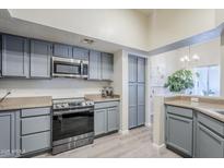 Well lit kitchen featuring stainless steel appliances, light countertops, and blue cabinets at 1331 W Baseline Rd # 360, Mesa, AZ 85202