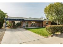Quaint single-Gathering home with a large front yard, mature trees, and a covered front porch at 2111 W Mulberry Dr, Phoenix, AZ 85015