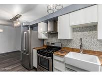 Modern kitchen featuring stainless steel appliances, wood countertops, and a stylish mosaic tile backsplash at 2941 N 19Th Ave # 95, Phoenix, AZ 85015
