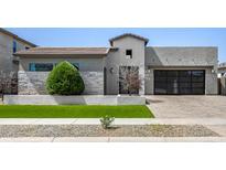 Contemporary home featuring desert landscaping, a modern facade, a tile roof and a three-car garage at 3822 E Canyon Pl, Chandler, AZ 85249