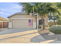 Charming single-story home featuring a two-car garage, beige exterior, and mature landscaping with a basketball hoop at 4111 S Dewdrop Ct, Gilbert, AZ 85297