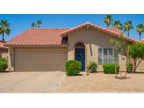 Charming home featuring a terra cotta roof, front yard desert landscaping, and a welcoming blue front door at 4216 E Sandia St, Phoenix, AZ 85044
