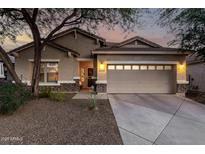 Charming home featuring a two-car garage, neutral stucco, stone accents, and a meticulously manicured landscape at 5113 W Molly Ln, Phoenix, AZ 85083