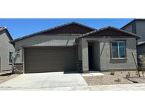 Charming single-story home featuring a two-car garage and desert landscaping at 5657 S 253Rd Ave, Buckeye, AZ 85326