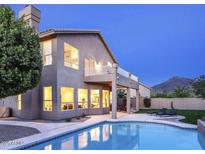 Inviting backyard with a sparkling pool, covered patio, and desert landscaping against a mountain backdrop at 9571 E Nittany Dr, Scottsdale, AZ 85255
