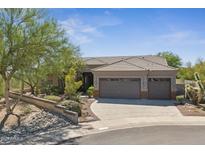 Charming desert home boasts a three-car garage, tile roof, and lush desert landscaping at 11008 N 119Th Pl, Scottsdale, AZ 85259