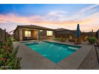 Backyard pool and spa with seating area, surrounded by updated landscaping and attractive sunset backdrop at 11951 W Wier Ave, Avondale, AZ 85323