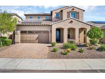 Two-story home featuring desert landscaping, tile roof, solar panels, and a two-car garage at 12932 W Cassia Trl, Peoria, AZ 85383