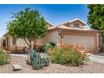 Charming home featuring desert landscaping and a cozy two-car garage at 13216 W Desert Ln, Surprise, AZ 85374