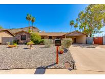 Charming stone facade home with desert landscaping, mature trees and an attached carport at 1326 W Joan De Arc Ave, Phoenix, AZ 85029