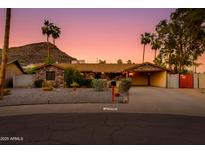 Charming stone home with lush landscaping and a covered carport provides curb appeal and convenience at 1326 W Joan De Arc Ave, Phoenix, AZ 85029
