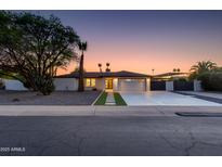 Charming single-story home with desert landscaping, a modern front entrance, and spacious driveway at 14012 N 57Th Pl, Scottsdale, AZ 85254